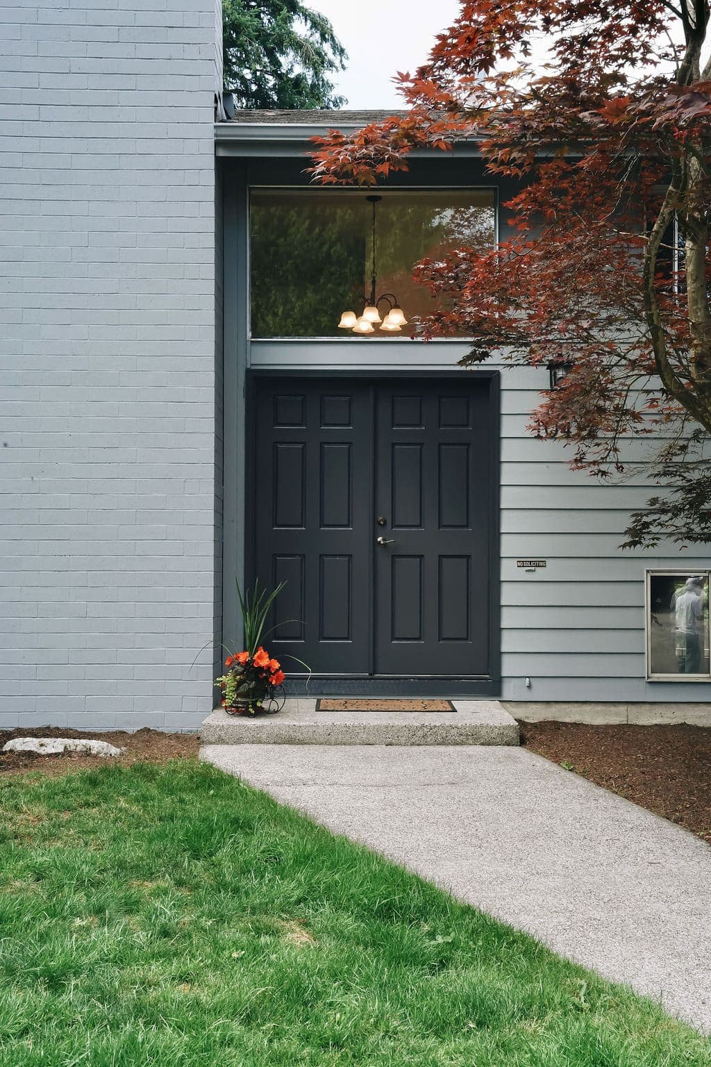 Repainted front entry of a Kirkland home with crisp charcoal doors and light gray siding